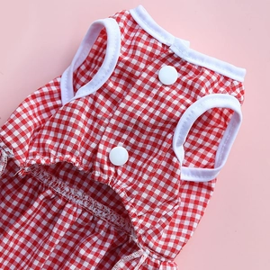 Detail view of red and white plaid dog dress featuring white snap buttons and cotton fabric