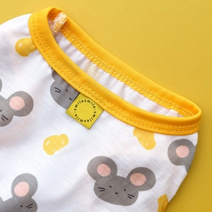 Close-up of pet vest featuring cartoon mouse print and yellow ribbed neckline detail
