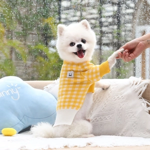 Close-up of yellow and white plaid knit dog sweater with ribbing and emoji patch