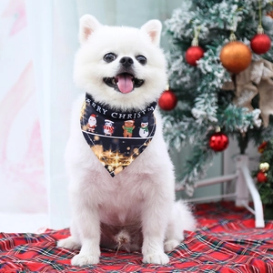 Pomeranian wearing Christmas dog bandana with cartoon characters and festive star patterns