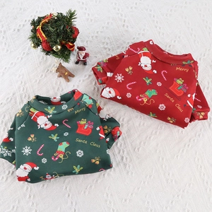 Close-up of festive red and green fleece pet sweaters with Christmas Santa prints