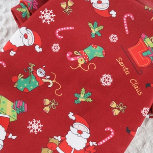 Close-up of festive red dog sweater with Santa Claus, reindeer and snowflake prints