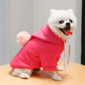 Détail d'un sweat à capuche rose pour animaux avec pompon rose et cordons blancs
