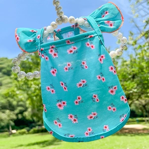 Robe florale bleu lac pour chien avec fleurs roses sur un cintre perlé en plein air