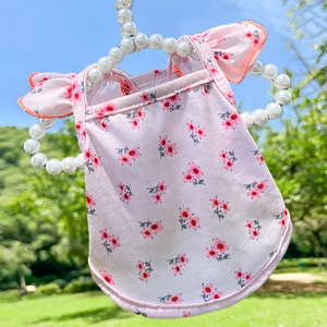 Robe rose pour animaux à fleurs rouges et volants sur un cintre en perles blanches