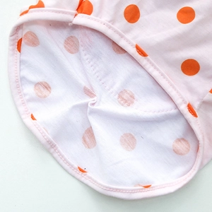 Gros plan détaillé du gilet en coton pour animaux rose avec des pois orange vifs