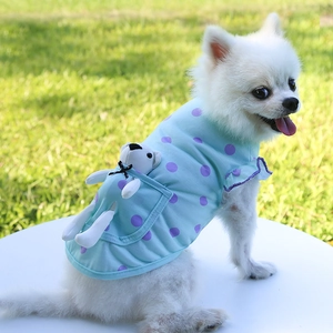 Détail d'un gilet pour animal avec motif à pois bleu clair et un ours en peluche dans la poche