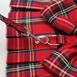 Detalle de arnés tipo vestido a cuadros rojos con anillo en D metálico y costuras firmes