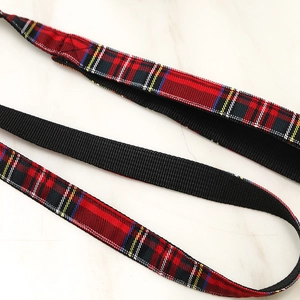 Detalle del patrón de cuadros rojos y nailon negro en el arnés para mascotas