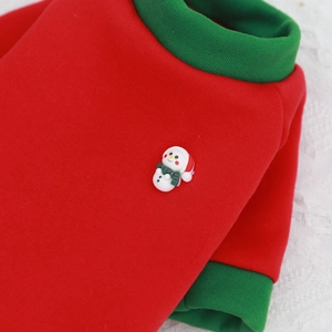 Detailed close-up of Christmas pet sweater with 3D snowman patch and red-green knit fabric