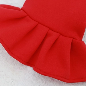 Macro detail of red pet clothes featuring ruffled pleats and fine knit fabric texture