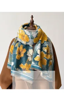 Détail d'un châle floral aux motifs jaune et vert avec des finitions à franges