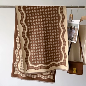 Vue détaillée de l'écharpe en jacquard double face avec motifs floraux marron et franges
