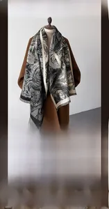 Detailed view of winter long scarf with black and white artistic floral patterns and tassels