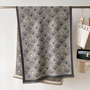 Détail du châle en maille avec motifs jacquard soleil et bords à franges douces