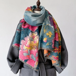Écharpe à imprimé pivoine avec franges sur un manteau gris sur un mannequin de bois