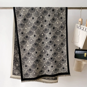 Détail d'un châle épais noir et blanc avec motif solaire et finitions à franges