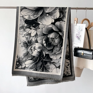 Dettaglio di uno scialle pashmina invernale con stampa floreale e frange fini