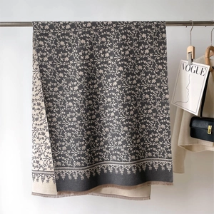 Detail of double-sided cashmere-like scarf with floral patterns and delicate fringe trim