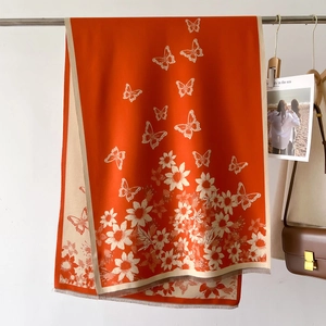Detail of floral butterfly scarf showing vibrant orange tones and fine tassel edges
