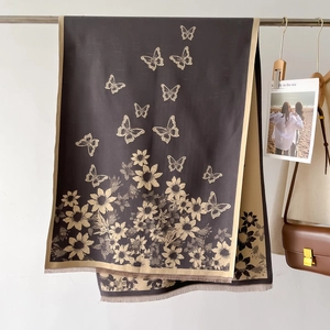 Detail of floral butterfly jacquard scarf featuring fringe edges and woven sunflower patterns