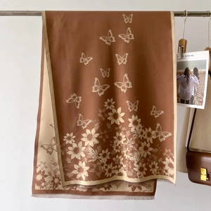 Macro view of vintage butterfly and floral jacquard patterns on soft tasseled shawl