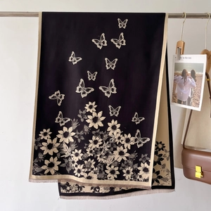 Detail of vintage knit shawl featuring beige floral and butterfly patterns with fringe