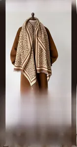 Detail of soft cashmere-like scarf showing warm geometric patterns and thick texture