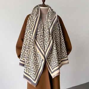 Close-up of geometric pattern cashmere scarf styled with a wool coat and fringe detail
