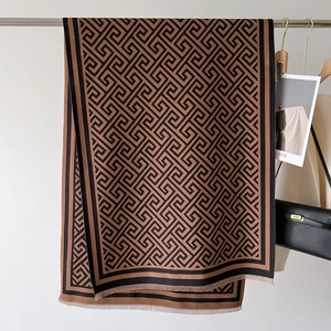 Detail of geometric Greek key pattern on thick cashmere scarf with delicate fringes