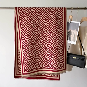 Detail of red and beige geometric Greek key cashmere feel scarf with fringe tassels