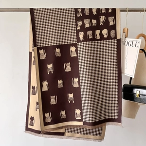 Detail of bicolor scarf with houndstooth pattern and cat print with fringe trim