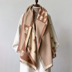 Detail of warm autumn scarf with houndstooth pattern and cute cat silhouettes