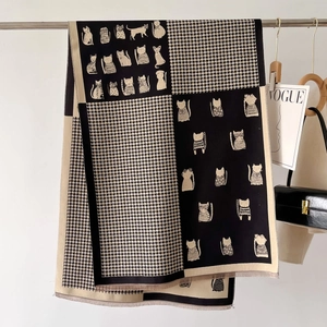Detail shot of winter scarf featuring cat illustrations, houndstooth pattern and fringes
