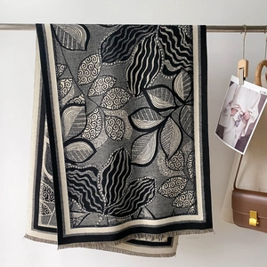 Detail of artistic leaf pattern and short fringes on thick faux cashmere scarf
