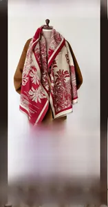 Detail of red and cream winter scarf with tropical palm pattern and soft fringed edges