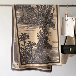 Detail of vintage beige scarf featuring brown palm tree prints and fringe edges