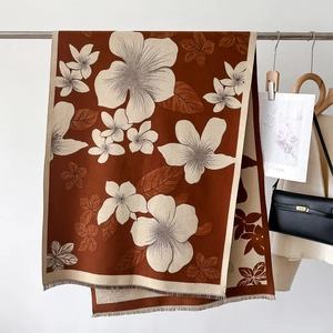Close-up of vintage floral knit scarf with elegant fringe detail in burnt orange