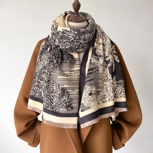 Retro cream shawl with black nature sketches and fringe, worn over a brown wool coat