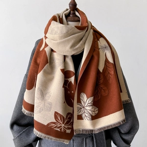 Detail of elegant thick scarf featuring dual-tone floral print and soft fringe trim