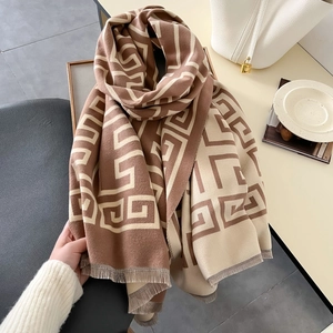 Detail of geometric pattern and soft tassels on a brown and beige knitted scarf