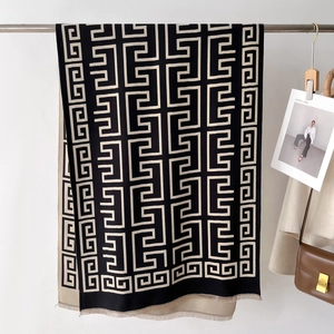 Detail of double-sided knit shawl with geometric maze pattern and soft fringe edges