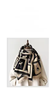 Detail of soft cashmere-like scarf featuring horse print and fine fringe edges