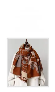 Dettaglio della sciarpa in maglia color-block con stampe marroni su cappotto bianco