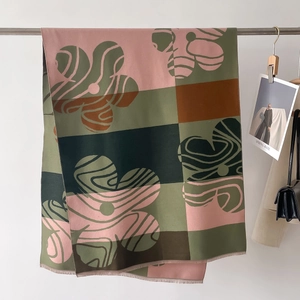 Dettaglio di sciarpa color-block con stampa floreale astratta e bordi a frange