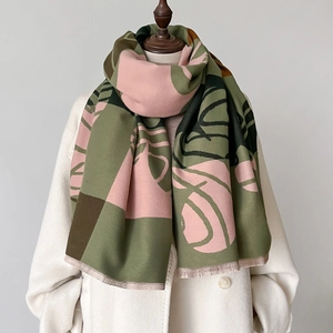 Vista dettagliata della sciarpa color-block con motivi di foglie su un cappotto beige