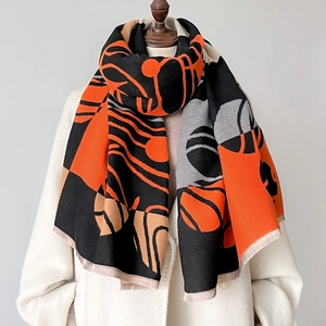 Elegante sciarpa con stampa geometrica arancione e grigia con frange su cappotto