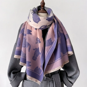Detailed view of cartoon cat pattern scarf with tassels on mannequin display