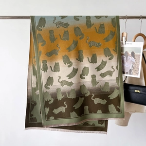 Detailed close-up of thick gradient knit scarf with fringe and cartoon cat jacquard