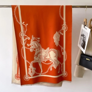 Detalle del estampado de caballos y cadenas en un chal grueso de cachemira con flecos